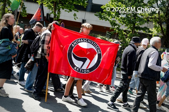 Ein Demonstrant spannt eine Fahne der "Antifaschistischen Aktion".
