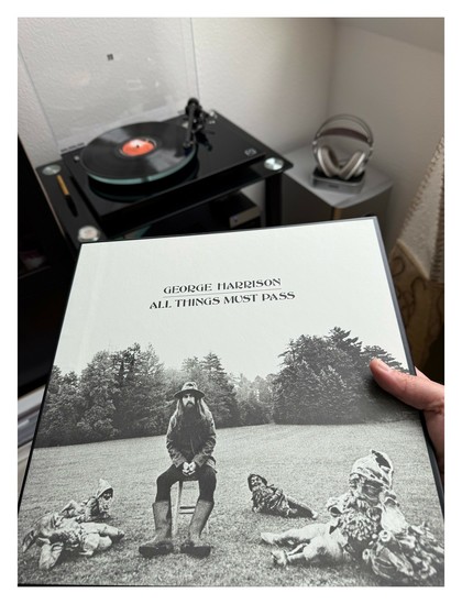 Auf einem schwarzen Plattenspieler läuft eine schwarze Schallplatte. Davor halte ich das Cover ins Bild. Schwarz-weiß Foto, George Harrison mit langen Haaren und Vollbart sitzt in Gärtnermontur (Schlapphut, Gummistiefel) auf einer Wiese. Um ihn herum liegen vier Gartenzwerge.