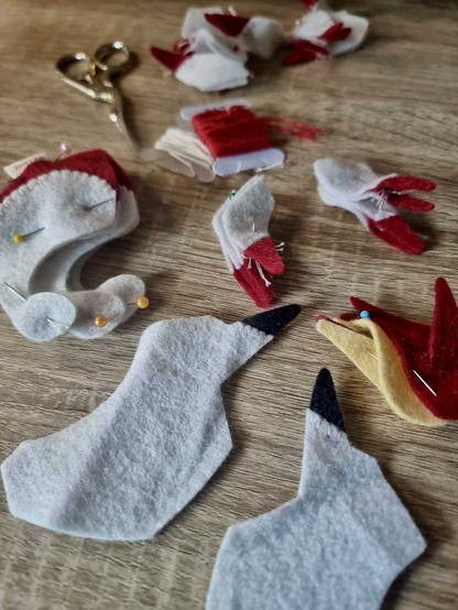 Loose pieces of felt pieces used to make a Kitsune plushie, spread on a wooden table.