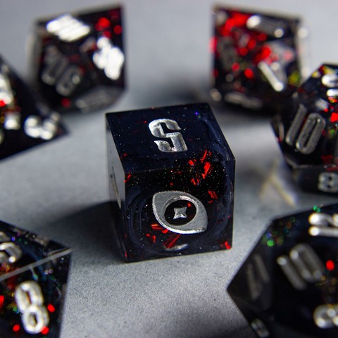 Zu sehen ist ein D6 mit schwarzen swirls. Die Swirls sind von roten Metallflakes und Glitter umgeben.

Die Nummern sind silber geinked. Die Zahl 6 wurde durch mein Logo, ein Auge mit Stern, ausgetauscht.