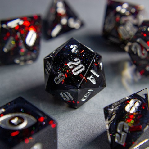 Zu sehen ist ein D20 mit schwarzen swirls. Die Swirls sind von roten Metallflakes und Glitter umgeben.

Die Nummern sind silber geinked.