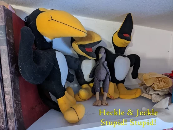 4 crow plushies on a shelf. 3 are hecle and Jeckle plushies.