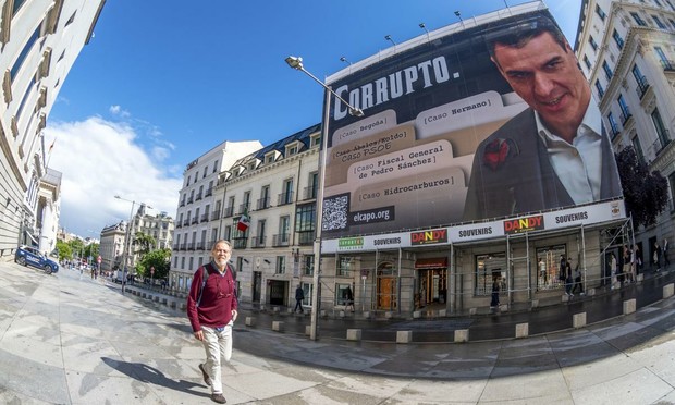 La lona con la imagen de Pedro Sánchez y la palabra "corrupto", en la fachada de un inmueble situado enfrente del Congreso, el 19 de mayo de 2025. (Fernando Villar / EFE)