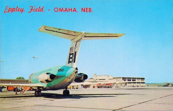 Your view is the back of the plane with the T tail hanging over you. You see blue skies and the terminal in the background.