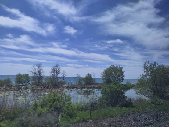 Foto. Ein Teich vor einem grossen See.