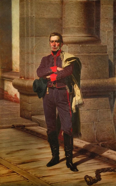 This image appears to be a portrait of a military officer or a person in a historical uniform, standing with arms crossed. The setting suggests a formal or ceremonial context, possibly from a past era. The details of the clothing, including the color and style, indicate rank and status. The backdrop includes architectural elements, suggesting a significant location. If you need more specific information or context about the painting, feel free to ask!

Image Credits: Wikimedia / Juan Manuel Blanes / Public domain