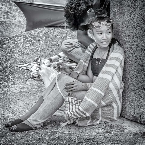 Young woman sitting beside stone column at the Chinese Cultural Center in Honolulu, Hawaii.