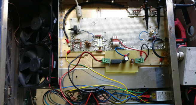 Photo de l’intérieur de l’ampli HF, dans son boîtier. On y voit la carte principale, déjà montrée ici, et une nouvelle carte plus petite juste en-dessous, avec une bobine, des condensateurs et un fusible. Sur la carte d’amplification, au milieu à droite, se trouve le système de mesure des puissances, avec deux sondes d’oscilloscope pour faire la mesure (pas fini !).