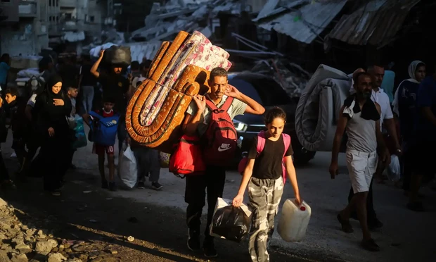 Palestinians carrying personal belongings during forced displacement in Central Gaza.
Eyad Baba