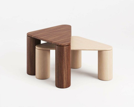 A minimalist wooden table set featuring two triangular tops in dark and light wood, paired with cylindrical legs.