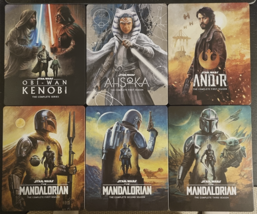 A photo of six Bluray boxes in high quality film printed steel boxes. They are, Obi-Wan Kenobi, Ahsoka, Andor Season 1, The Mandalorian Seasons 1 to 3.