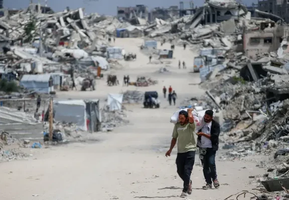 Palestinians flee with their belongings after the Israeli military issued orders forcing people out of northern Gaza, on May 22, 2025 [Mahmoud Issa/Reuters]