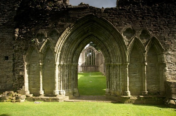 The gothic arched doorway of a ruined medieval church building