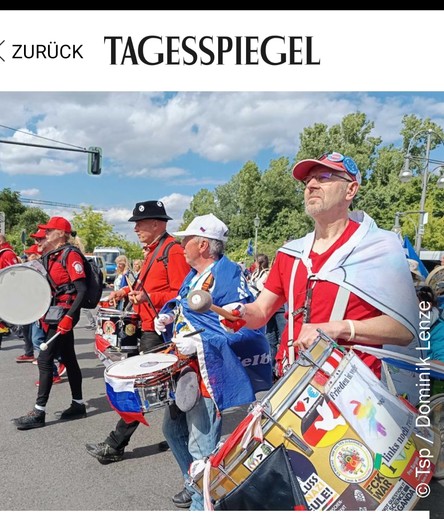 Mehrere verkleidete querdenkende berentete, politisch verwirrte Männer mit Trommeln.