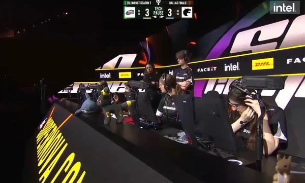 Wide shot of the ESL Impact Season 7 Dallas Finals stage showing the Supernova Comets team at their gaming stations with the BLÅHAJ shark visible on their player desk. The scoreboard shows a 3-3 tie during a tech pause. The stage features dramatic purple and yellow lighting with sponsor branding, and the shark maintained its place throughout the competitive match.