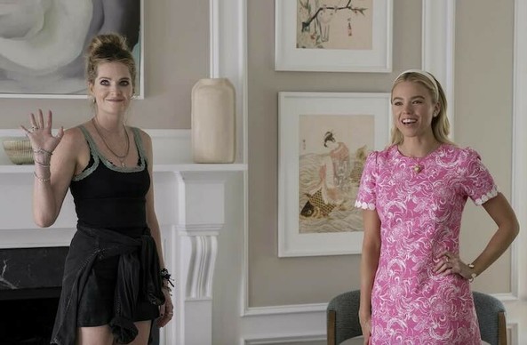 Meghann Fahy and Milly Alcock in a beautiful room with expensive art on the walls. One is dressed in shorts and a tank top looking like discount store goods and the other is in an expensive dress.