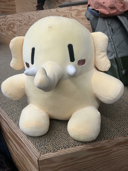 The Mastodon plush sitting on stairs