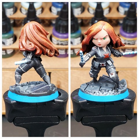 Collaged photo of the front and back of a painted Black Widow miniature standing atop a paint handle.