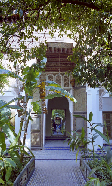 A courtyard garden, with an ornate, Moorish doorway beyond.
