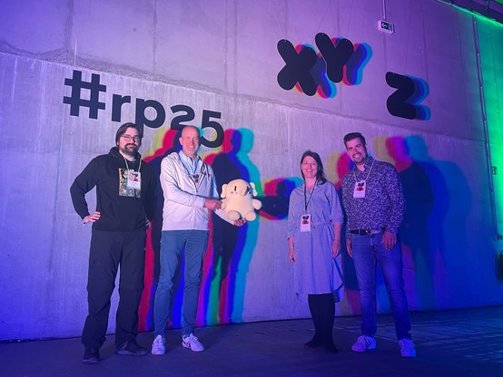 The Mastodon-Team and SaveSocial with Plushtodon in front of the re:publica photo wall.