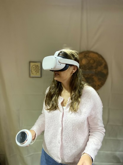 Une personne avec des lunettes de réalité virtuelle et des manettes.