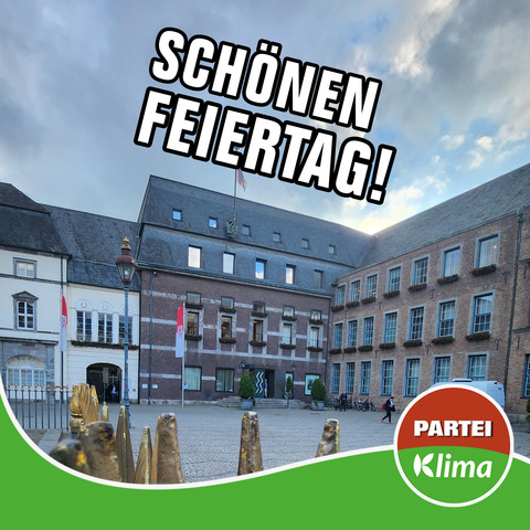 Zu sehen ist die Front des Düsseldorfer Rathauses. Darüber steht in weißer Schrift: „Schönen Feiertag!“