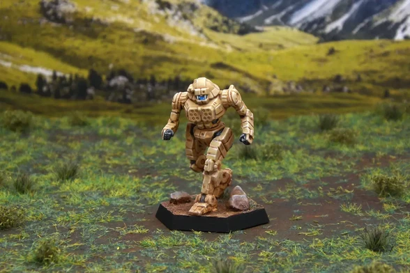 A painted miniature of a Javelin 'Mech.  It is tan and the cockpit glass is blue.  The miniature is photographed on grassy terrain.