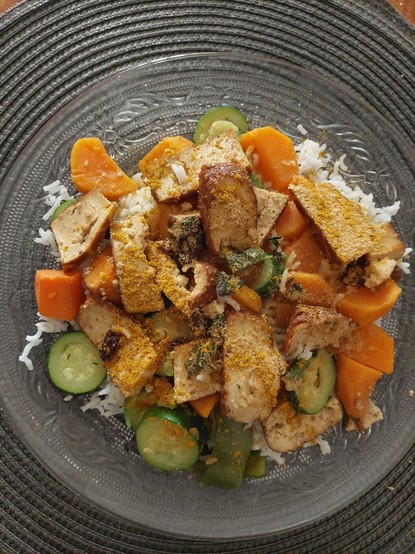 Assiette végétalienne repas composée de riz basmati, légumes cuits à l'eau et quart de bouillon cube végétal, gingembre: Deux petites patates douce,une carotte, un reste de poivron vert, une courgette. Poêlée  de tofu rôti  à la crème végétale de soja.  poudre de curry et levure maltée ajoutées dans l'assiette, quelques raisins secs