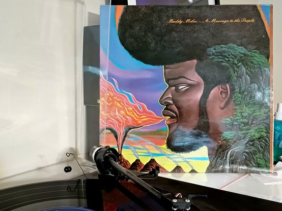Kuvassa afrokampauksinen Buddy Miles sylkee suustaan tulta.