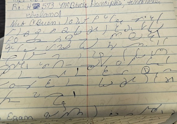 photo of yellow notebook paper. at the top in English is "Re: H 573 McBride Principles, Finances, Ireland
Herb O'Brien" followed by shorthand, which looks like a bunch of squiggly lines but is a code used by stenographers. Near the bottom is "Egan" mixed in with the shorthand.
