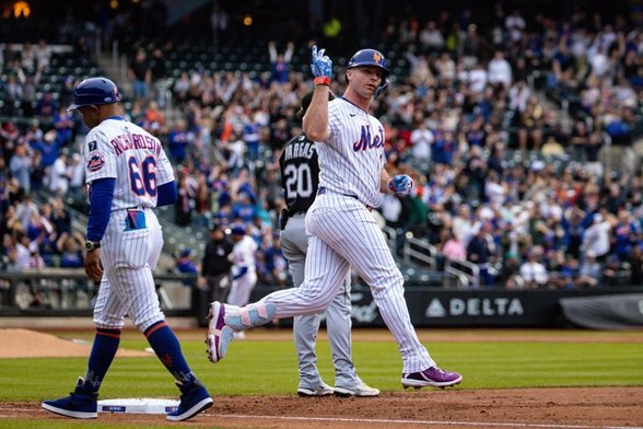 The New York Mets' Pete Alonso rounds third, with his right arm raised, while finishing up his home run trot against the Chicago White Sox on Tuesday night in Queens.