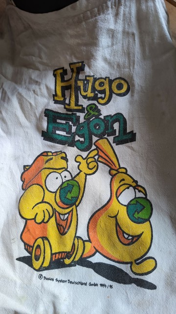 Ein Stoffbeutel mit den Maskottchen des Dualen Systems: Hugo & Egon (eine gelbe Tonne und ein gelber Sack mit dem grünen Punkt als Nase)