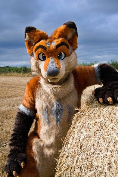Terrence is leaning on a hay bail