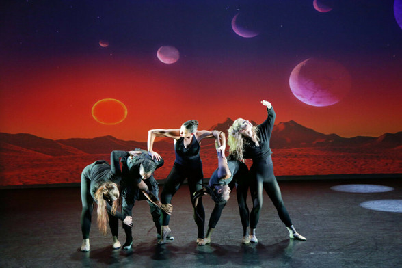 Five female dancers on stage. They connect via arms and legs in various directions.