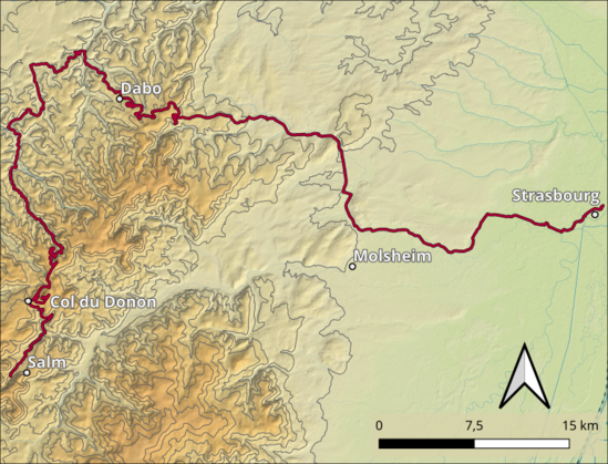 Das Bild zeigt eine topografische Karte, die eine Route von Dabo nach Strasbourg hervorhebt. Die Route ist in einem roten Konturlinienzug dargestellt und verläuft durch verschiedene geografische Merkmale. Dabo liegt im Norden, und Strasbourg im Süden. Zwischen diesen beiden Städten befinden sich die Orte Col du Donon und Molshem. Die Karte zeigt die Höhenlinien, die die topographische Struktur der Region darstellen, mit dunkleren Linien für höhere Gebiete und helleren Linien für niedrigere Gebiete. Ein Skalierungsstab im unteren rechten Bereich zeigt die Entfernung in Kilometern. Ein Kompassrose zeigt die Richtung. Die Karte ist detailliert und bietet eine klare Darstellung der geografischen Lage und der Route.