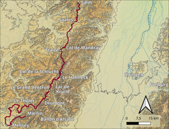 Das Bild zeigt eine topografische Karte, die eine Bergstraße in der Region des Ballon d'Alsace in Frankreich darstellt. Die Karte ist in braunen und beigefarbenen Tönen gehalten, wobei die Höhenlinien deutlich sichtbar sind, um die topographische Struktur der Gegend zu veranschaulichen. Eine rote Linie markiert die Route der Straße, die von Melisey im Süden bis zum Ballon d'Alsace im Norden führt.

Die Karte zeigt mehrere markante Punkte entlang der Route, darunter Salm, Saales, Fraize, Col de Mandray, Col de la Schlucht, Le Hohneck, Le Grand Ventron, Lac de Kruth, Drumont, Miellin, Ballon d'Alsace und Ihringen. Freiburg ist ebenfalls auf der Karte zu sehen, obwohl es nicht direkt auf der Route liegt.

Ein Kompassrose in der unteren rechten Ecke zeigt die Richtung der Karte, und eine Maßstabskennlinie in der unteren rechten Ecke gibt die Entfernungen an, wobei 0, 7,5 und 15 Kilometer markiert sind. Die Karte bietet eine detaillierte Darstellung der geographischen und topographischen Merkmale der Region, einschließlich der Höhenunterschiede und der Flussläufe.
