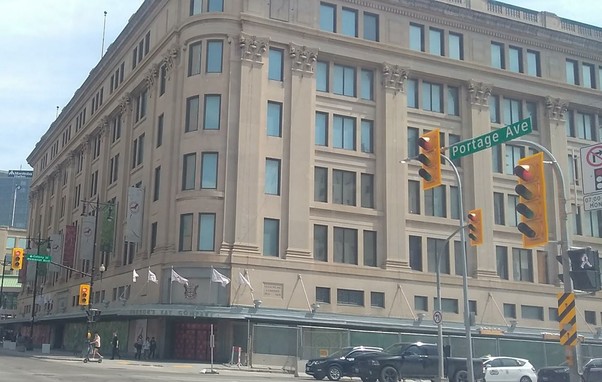 Colour photo of the former Hudson's Bay Company Building in downtown Winnipeg, looking southeast from the corner of Portage Avenue and Memorial Boulevard.
The building is six storeys and has a slight Art Deco style to it.