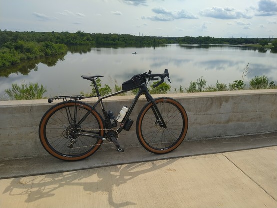 Bicycle leaning against a short stone wall overlooking the reservoir at Lakeline Park in Cedar Park, TX.