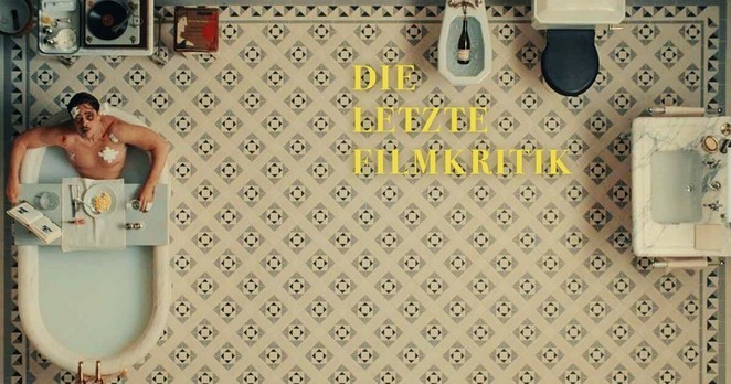 Ein mit symmetrischen Blumenmustern gekacheltes Badezimmer aus der Vogelperspektive und wir sehen Benicio del Toro als Zsa-Zsa Korda in einer vollen Badewanne sitzend zu uns auf blicken. Coverbild des Podcasts "Die Letzte Filmkritik".