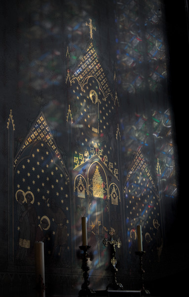 Photo d’un mur de la cathédral, frappé d’un faisceau lumineux coloré venant du vitrail sur la droite