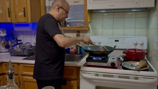 Stir-frying beef in a wok (on a butane burner) in May 2005.