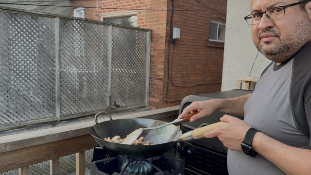 Screenshot from a video my wife took in May 2004 of me stir-frying beef with mushrooms on an outdoor wok burner.