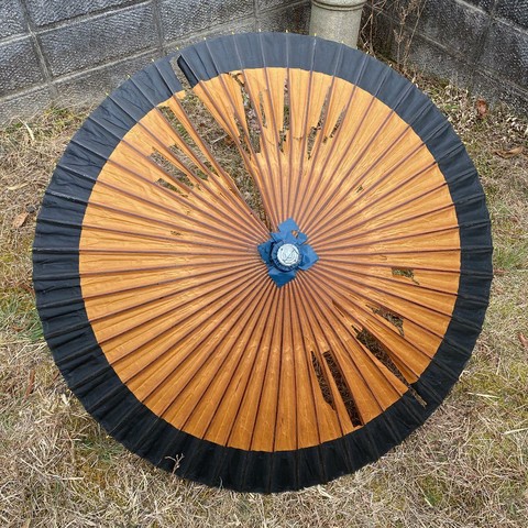 A tattered old parasol, ell on its way to becoming a kasa-obake.