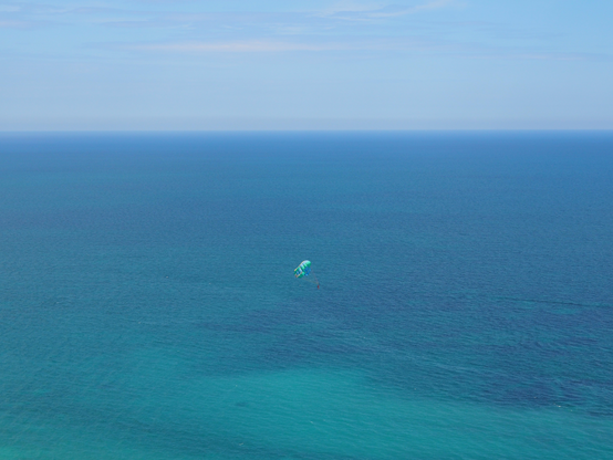 Parasailing über dem Meer. Schirm, Meer und Himmel in blauer Farbharmonie.
