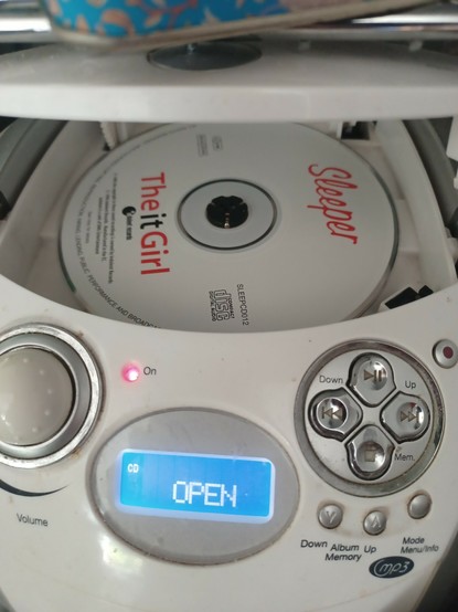 It's The It Girl by Sleeper, copyright 1996. A compact discette in a bug-head–shaped CD player.
