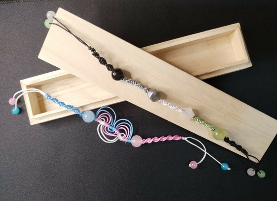 a bracelet with the transgender pride flag palette and a bracelet with the agender pride flag palette.