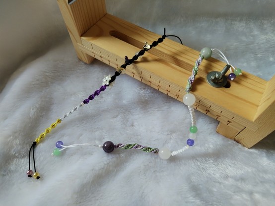 a bracelet with the non-binary pride flag palette and a bracelet with the genderqueer palette.