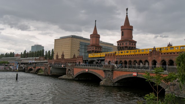 Ein gelber Wagen der Linie U1 fährt über die Spree auf der Oberbaumbrücke.