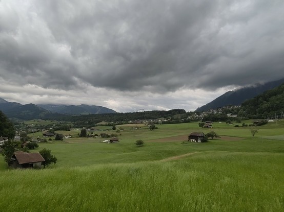 Dark clouds over green meadows in a mountain landscape