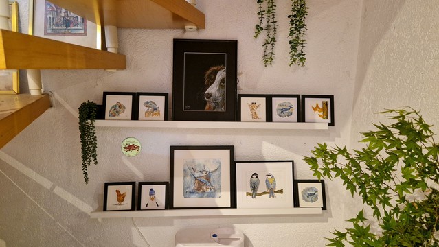 Auf zwei Borden aufgereiht sind 11 handgemalte Bilder, eins davon ein unverkäufliches Portrait meiner Hundedame auf den anderen zweimal Chamäleon  zweimal Wal, einmal Möwe mit Mütze, einmal Giraffe, einmal Eichhörnchen,einmal Huhn und ein größeres Bild mit Rochen und ein größeres mit Blaumeise und Kohlmeise
